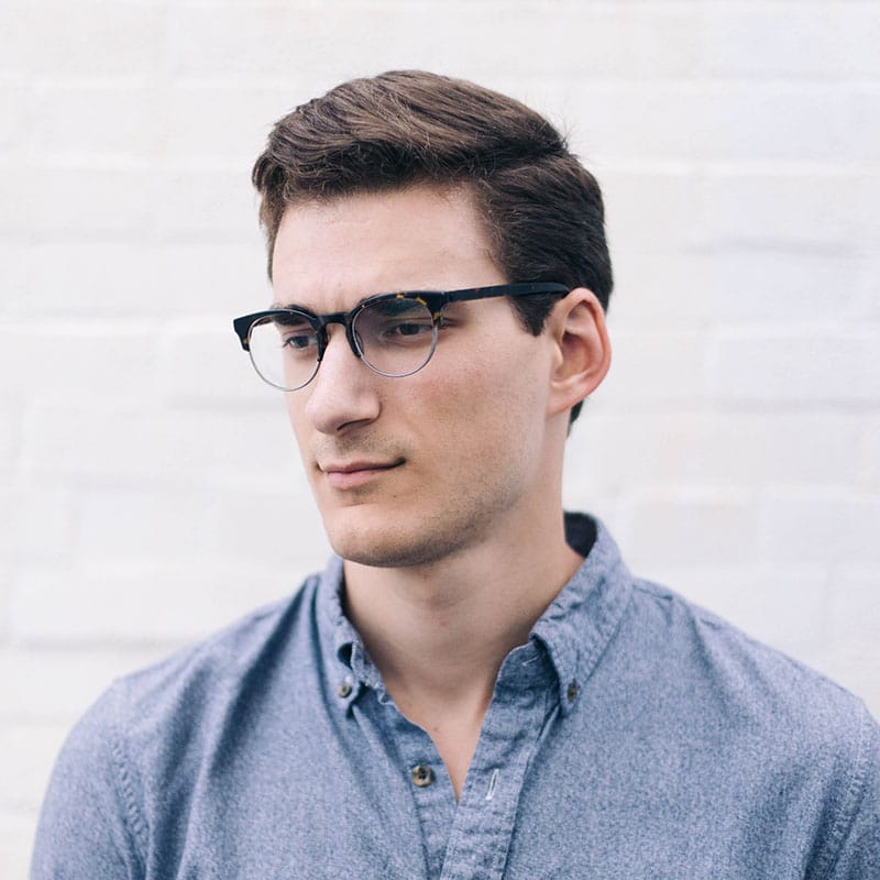 a man wearing glasses and looking at the camera